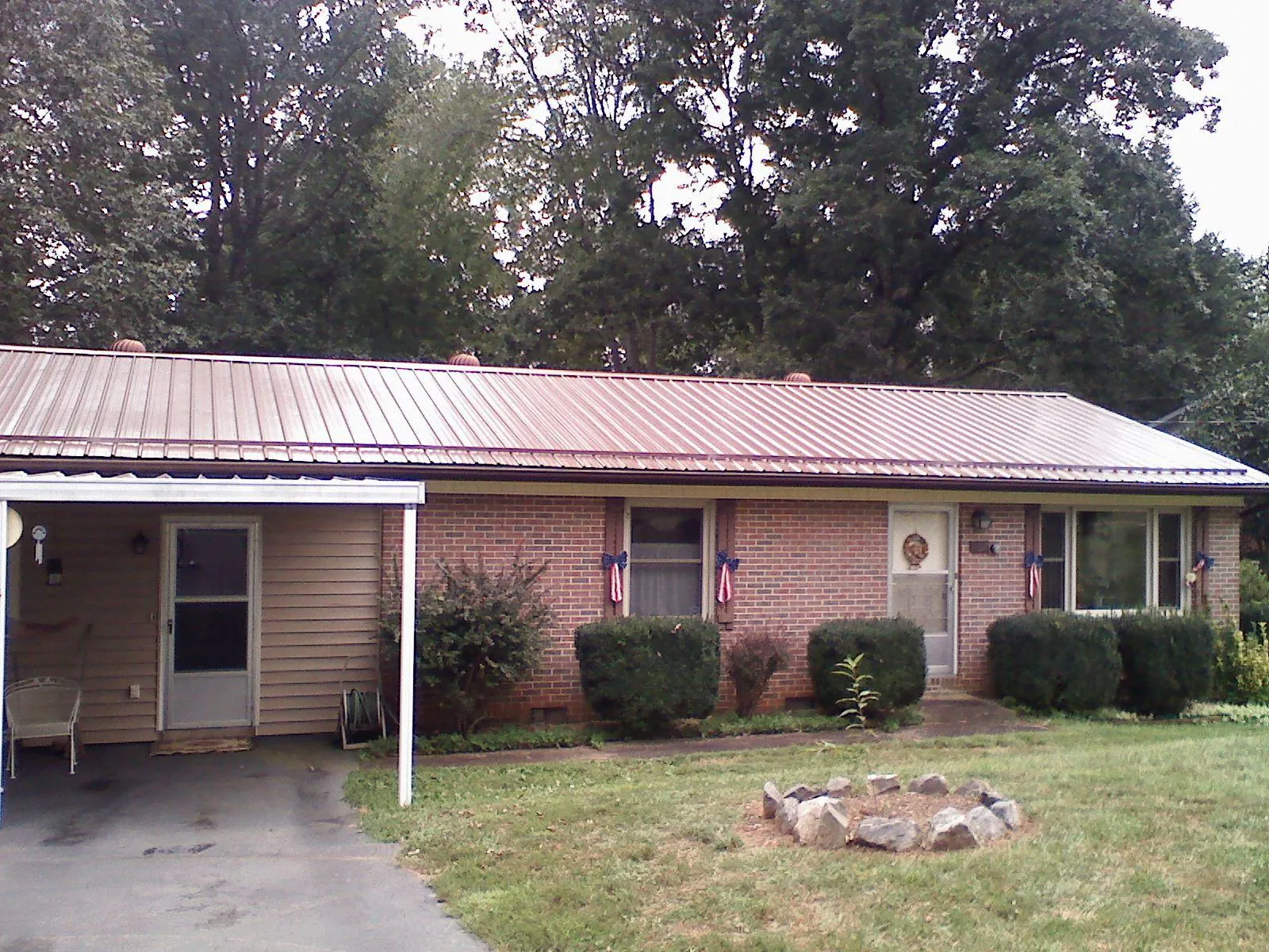 Bronze metal roof and carport on a brick ranch home — Roof Repair work by our crew in West Liberty